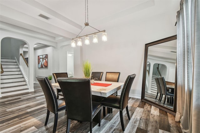 dining space featuring stairway, dark wood finished floors, baseboards, and beam ceiling