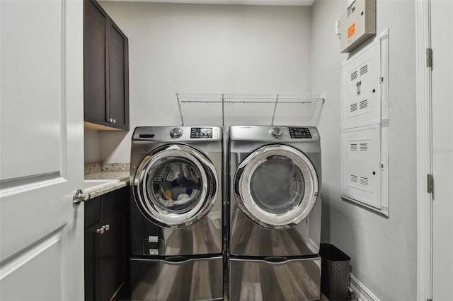 washroom with cabinet space, washer and clothes dryer, and baseboards