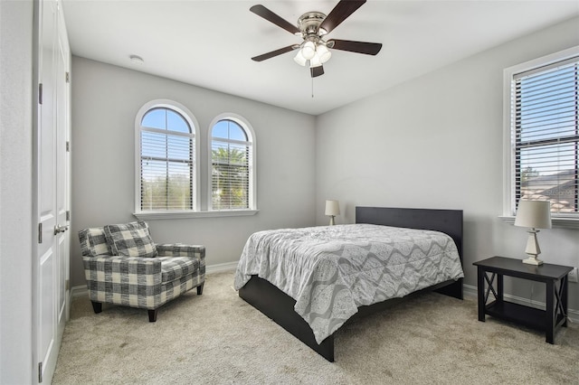 carpeted bedroom with baseboards and a ceiling fan