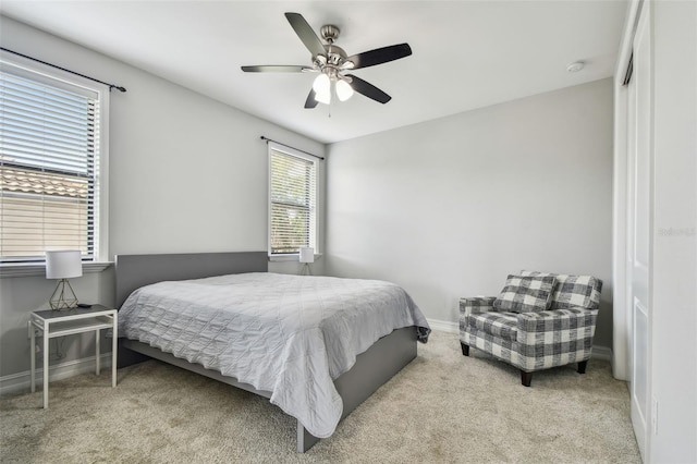 carpeted bedroom featuring baseboards and ceiling fan