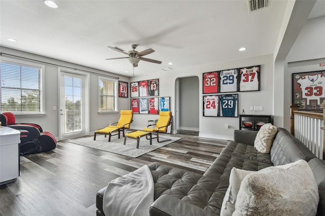 living area featuring plenty of natural light, recessed lighting, wood finished floors, a ceiling fan, and arched walkways