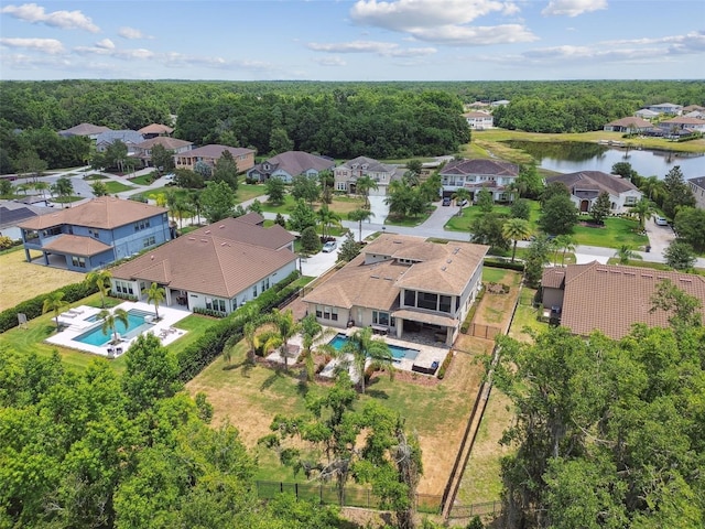 aerial view of residential area with a pool and a large body of water