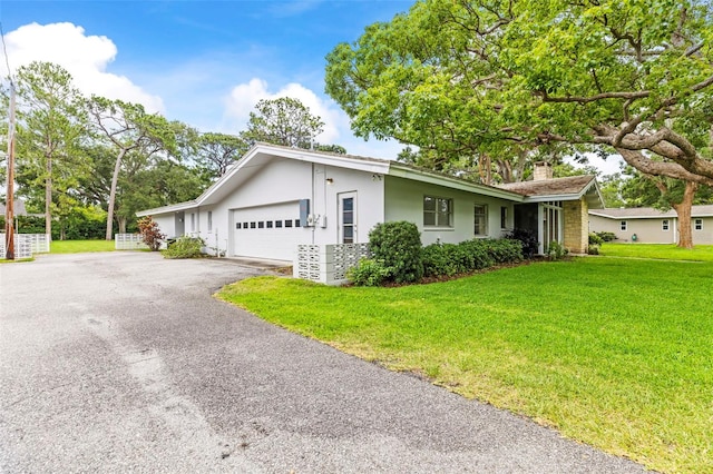 1675 Robin Hood Ln, Clearwater, FL 33764 - single story home with a garage, a front yard, driveway, a chimney, and stucco siding