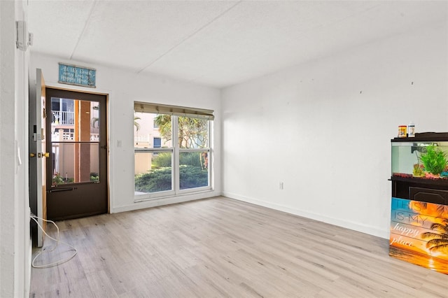 empty room featuring wood finished floors and baseboards