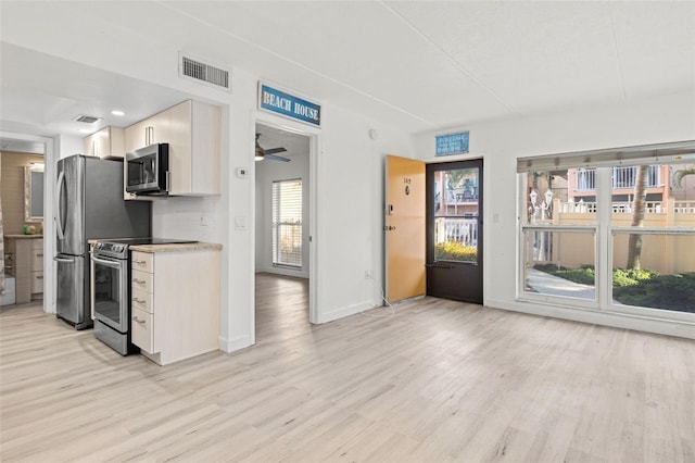 kitchen with stainless steel appliances, light wood-style floors, baseboards, light countertops, and white cabinetry
