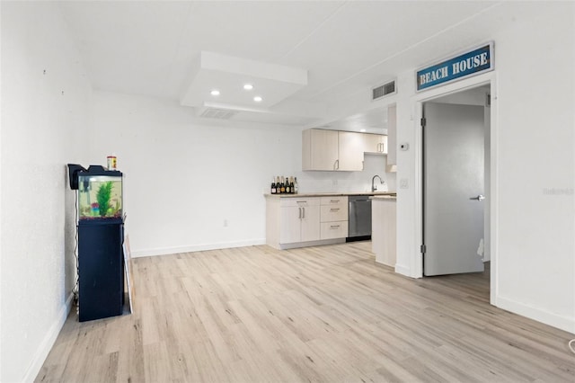 kitchen with stainless steel dishwasher, light wood finished floors, baseboards, recessed lighting, and light countertops
