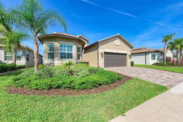 15525 Corona Del Mar Dr, Wimauma, FL 33598 - view of front of house with stucco siding, decorative driveway, an attached garage, and a front lawn