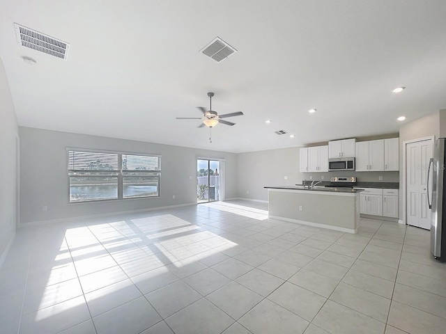 11524 Sage Canyon Dr, Riverview, FL 33578 - kitchen featuring stainless steel appliances, open floor plan, light tile patterned floors, white cabinets, and ceiling fan