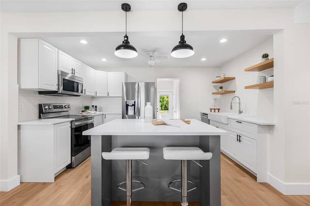526 62nd Ave NE, Saint Petersburg, FL 33702 - kitchen with appliances with stainless steel finishes, a breakfast bar, light wood finished floors, open shelves, and recessed lighting