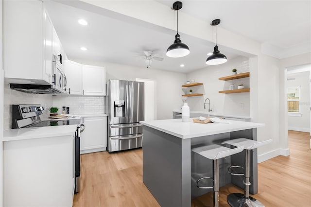 526 62nd Ave NE, Saint Petersburg, FL 33702 - kitchen with stainless steel appliances, open shelves, a kitchen breakfast bar, light countertops, and recessed lighting