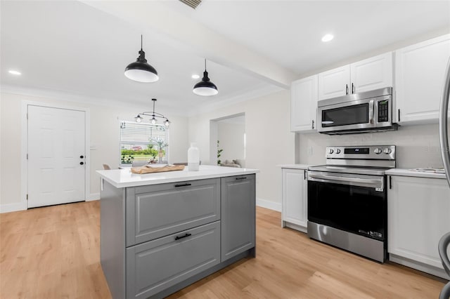 526 62nd Ave NE, Saint Petersburg, FL 33702 - kitchen with appliances with stainless steel finishes, white cabinetry, a kitchen island, light countertops, and gray cabinetry
