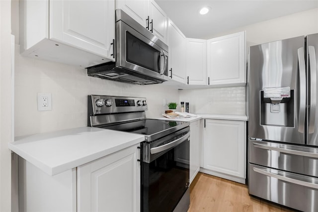 526 62nd Ave NE, Saint Petersburg, FL 33702 - kitchen with appliances with stainless steel finishes, white cabinets, light countertops, tasteful backsplash, and recessed lighting