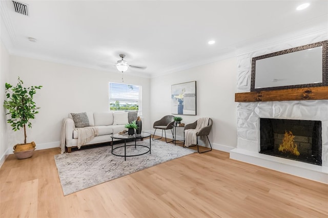 526 62nd Ave NE, Saint Petersburg, FL 33702 - living room featuring wood finished floors, ornamental molding, baseboards, a fireplace, and a ceiling fan