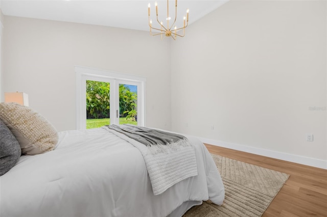 526 62nd Ave NE, Saint Petersburg, FL 33702 - bedroom featuring access to outside, a chandelier, baseboards, wood finished floors, and vaulted ceiling