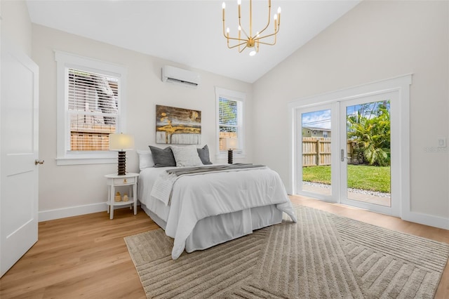 526 62nd Ave NE, Saint Petersburg, FL 33702 - bedroom with a wall mounted AC, access to outside, a chandelier, light wood-style flooring, and baseboards