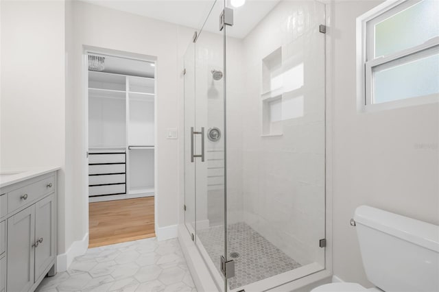526 62nd Ave NE, Saint Petersburg, FL 33702 - bathroom with toilet, a shower stall, vanity, tile patterned floors, and a spacious closet