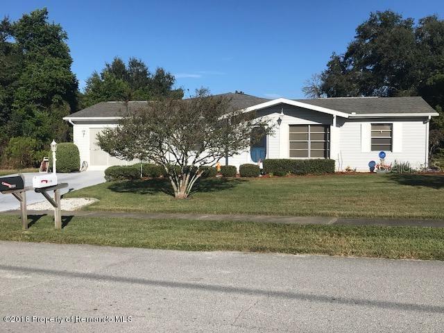 single story home featuring concrete driveway, a garage, and a front lawn
