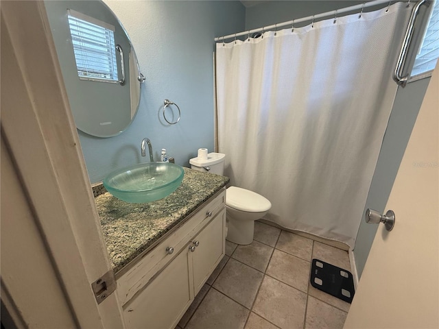 bathroom featuring tile patterned flooring, toilet, vanity, and plenty of natural light