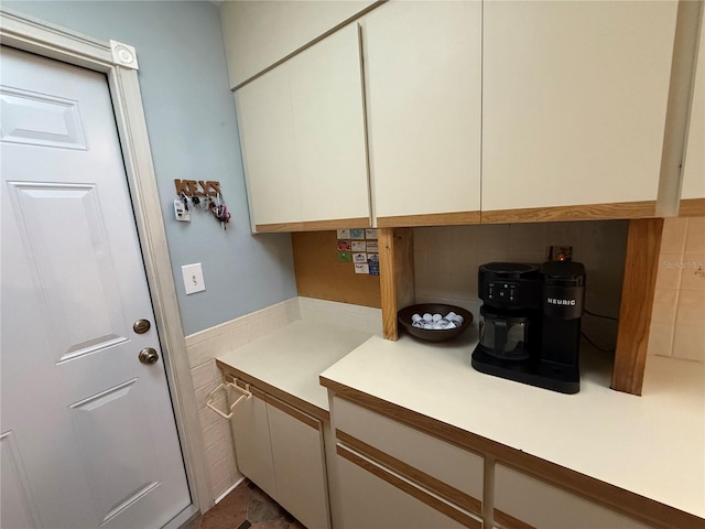 laundry area featuring tile walls and wainscoting