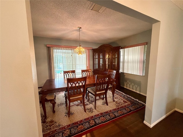 dining area with a textured ceiling and baseboards