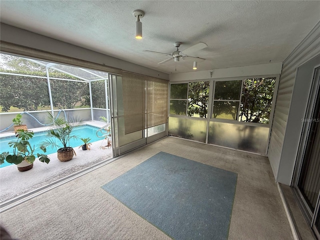 unfurnished sunroom with ceiling fan