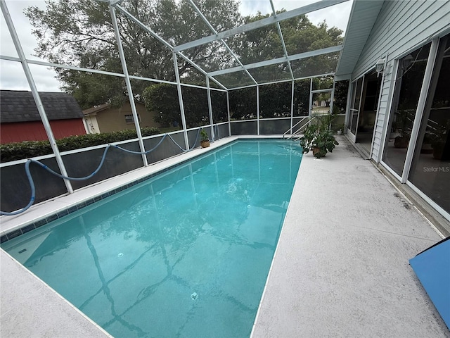swimming pool with glass enclosure and a patio area