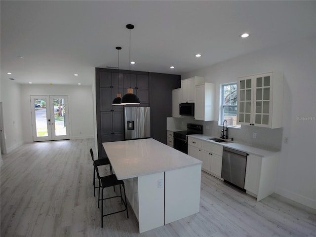 7013 N 15th St, Tampa, FL 33610 - kitchen with black appliances, a sink, light wood-style floors, a breakfast bar, and plenty of natural light