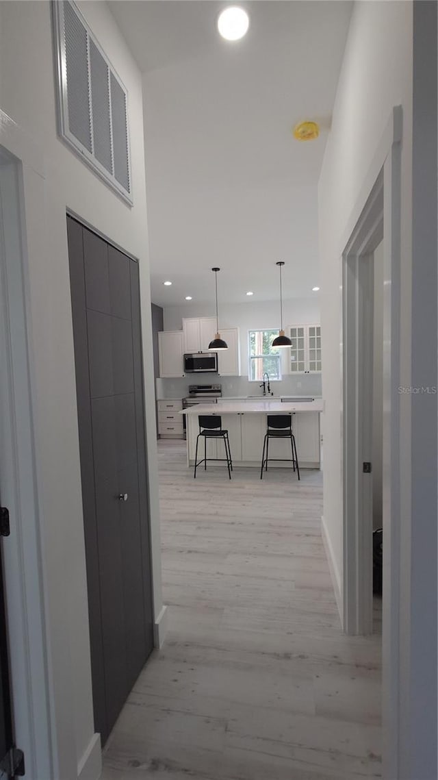 7013 N 15th St, Tampa, FL 33610 - corridor featuring light wood-type flooring, recessed lighting, a sink, and baseboards