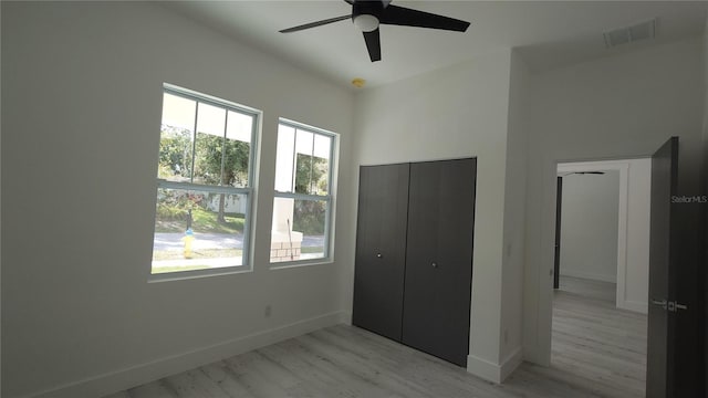 7013 N 15th St, Tampa, FL 33610 - unfurnished bedroom featuring multiple windows, light wood-style floors, and baseboards