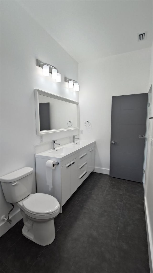 7013 N 15th St, Tampa, FL 33610 - bathroom featuring toilet, double vanity, baseboards, and tile patterned floors