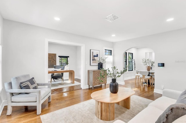 2859 Dartmouth Ave N, Saint Petersburg, FL 33713 - living room featuring arched walkways, plenty of natural light, light wood-type flooring, recessed lighting, and baseboards