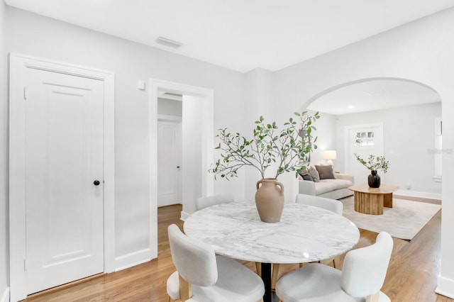 2859 Dartmouth Ave N, Saint Petersburg, FL 33713 - dining room with arched walkways, light wood-style flooring, and baseboards