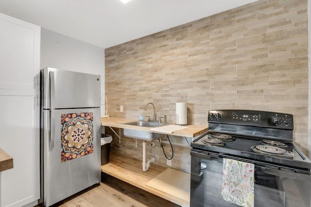 2859 Dartmouth Ave N, Saint Petersburg, FL 33713 - kitchen featuring freestanding refrigerator, electric range, tasteful backsplash, light wood finished floors, and wooden counters