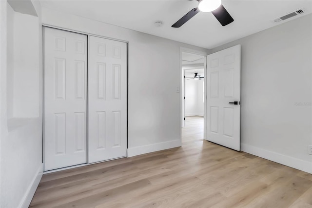 unfurnished bedroom featuring light wood-style flooring, baseboards, a closet, and a ceiling fan