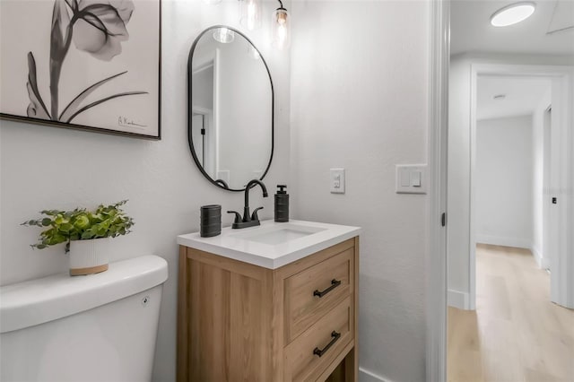 bathroom featuring vanity, wood finished floors, and toilet