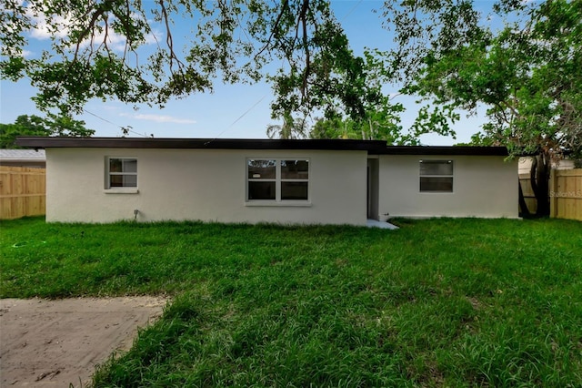 rear view of house featuring stucco siding