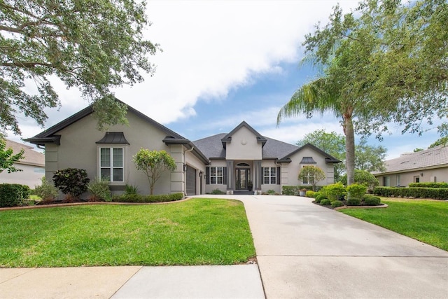 view of front of home with concrete driveway, stucco siding, an attached garage, and a front lawn