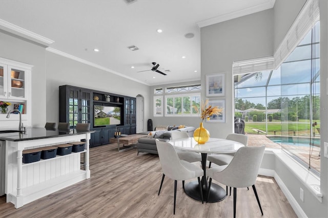 dining space with light wood-type flooring, recessed lighting, ceiling fan, ornamental molding, and baseboards