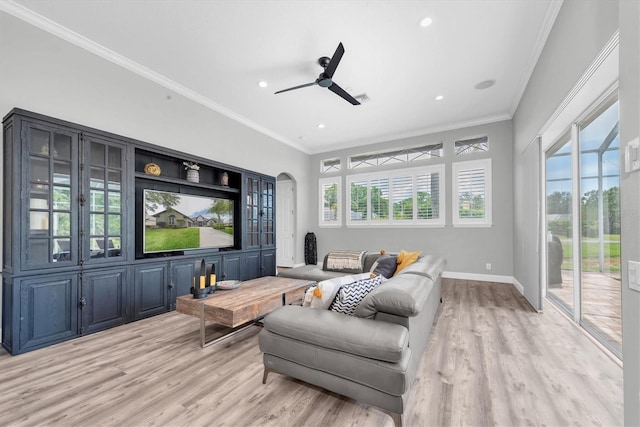 cinema room featuring light wood finished floors, baseboards, healthy amount of natural light, crown molding, and ceiling fan