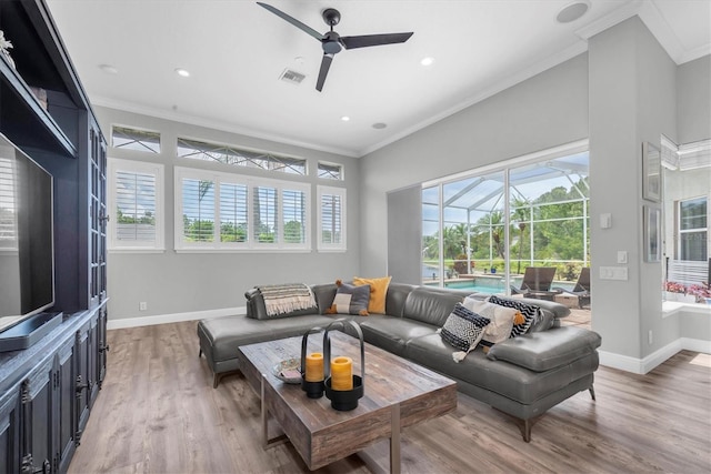 living room featuring crown molding, ceiling fan, a sunroom, light wood finished floors, and baseboards