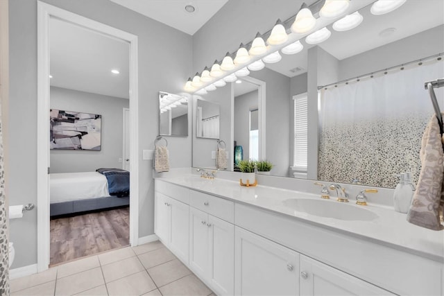 bathroom featuring tile patterned floors, double vanity, connected bathroom, and baseboards