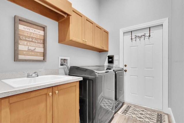 laundry area featuring independent washer and dryer, cabinet space, and wood finished floors