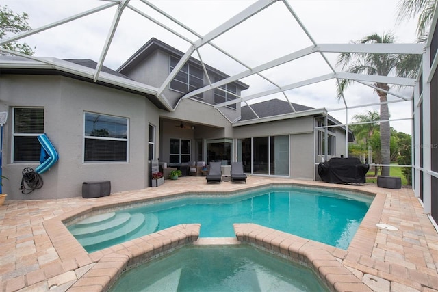view of swimming pool with a patio, a ceiling fan, a pool with connected hot tub, and a lanai