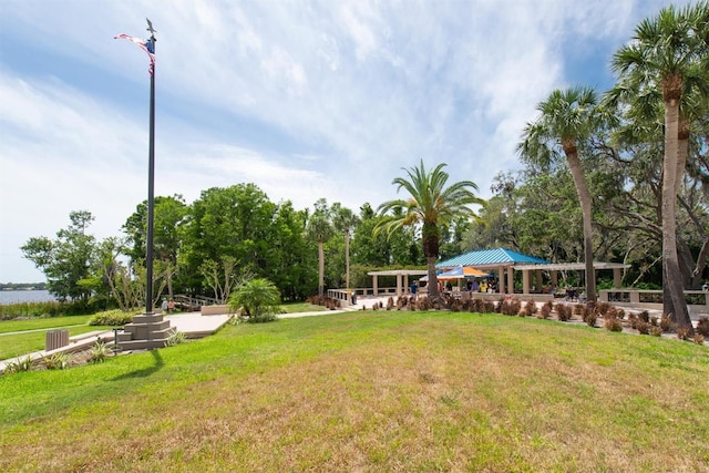 view of green lawn featuring a gazebo and view of wooded area