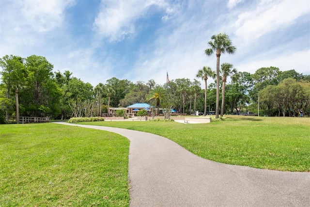 surrounding community with a lawn and view of scattered trees