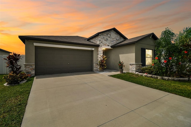 13603 Wild Ginger St, Riverview, FL 33579 - view of front of property with stone siding, stucco siding, a garage, concrete driveway, and a yard