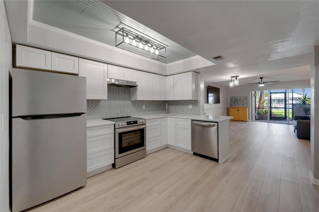 1028 Apollo Beach Blvd Unit 21, Apollo Beach, FL 33572 - kitchen featuring appliances with stainless steel finishes, under cabinet range hood, white cabinets, backsplash, and crown molding