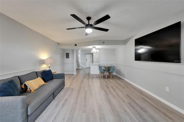1028 Apollo Beach Blvd Unit 21, Apollo Beach, FL 33572 - living room with light wood finished floors, a textured ceiling, a ceiling fan, baseboards, and stairs