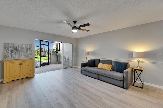 1028 Apollo Beach Blvd Unit 21, Apollo Beach, FL 33572 - living area featuring baseboards, a ceiling fan, light wood-type flooring, and a textured ceiling