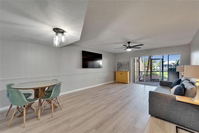 1028 Apollo Beach Blvd Unit 21, Apollo Beach, FL 33572 - living room with a ceiling fan, light wood-style floors, baseboards, and a textured ceiling